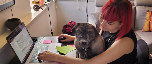 Pet expert and content creator, Liv working from home with her dog Jackson on her lap