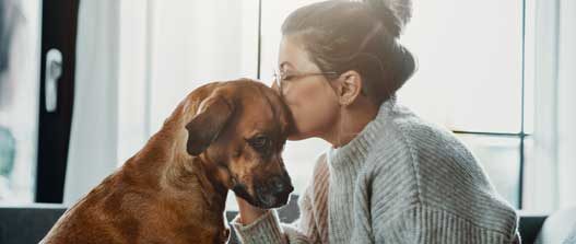 women kissing dog's head