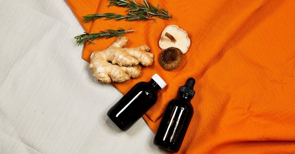 Image of 2 NHV amber glass bottles with rosemary sprig, piece of ginger and shiitake mushroom