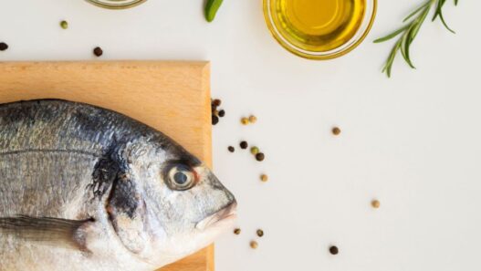 Photo of a table top with a fish on a cutting board to illustrate a blog about the benefits of Cod Liver Oil, Sardines and Anchovies for Dogs & Cats.